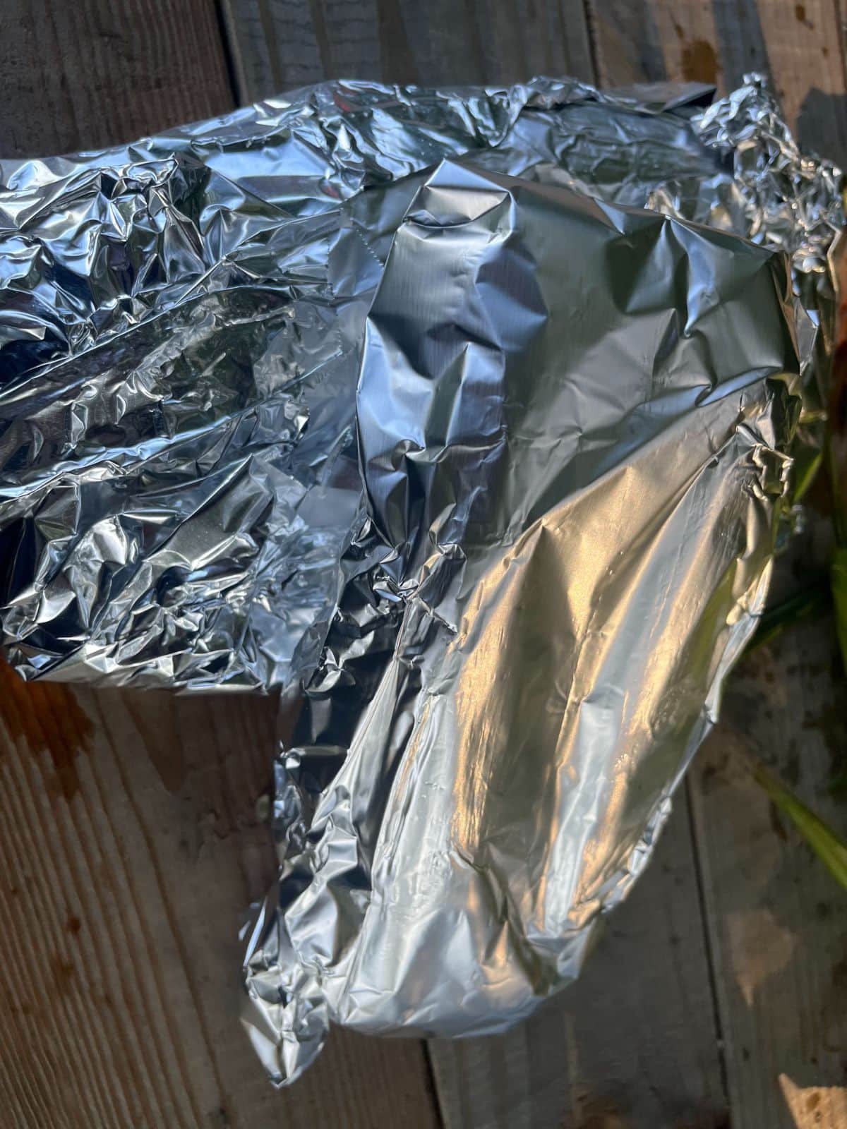 Ears of soaked corn on the cob wrapped in foil