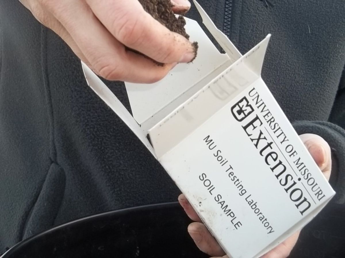 A person filling a soil sample bag for testing for roses