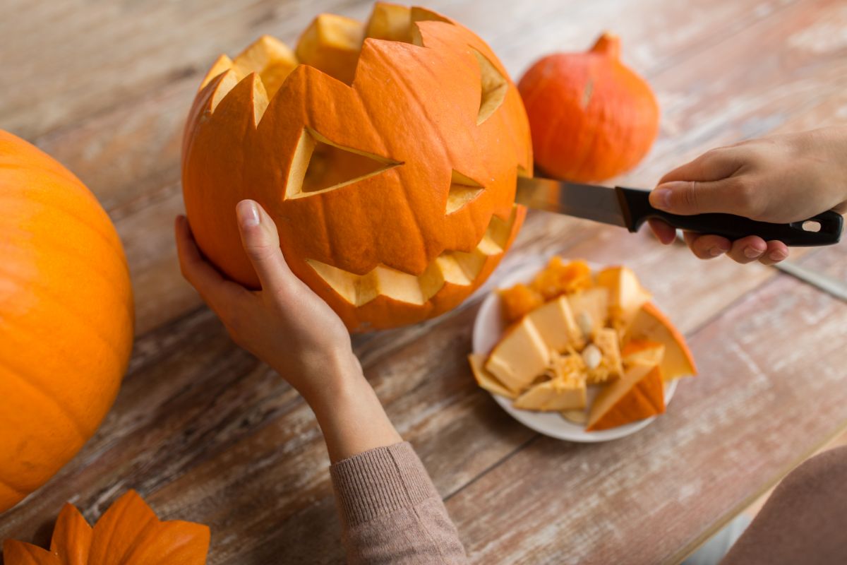 A pumpkin being carved into a jack-o-lantern