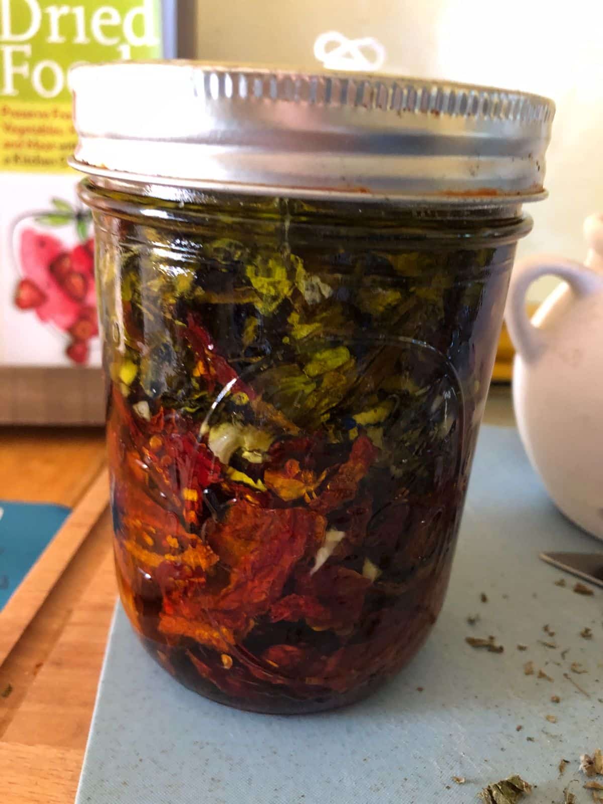 A jar of dried tomatoes and basil in olive oil