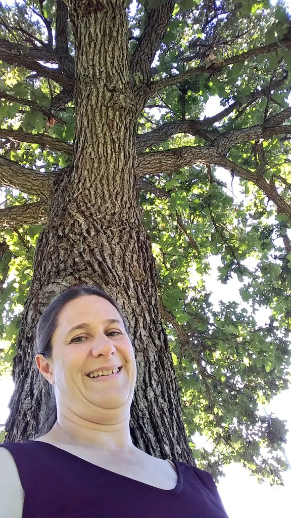 Gardener standing next to a burr oak tree