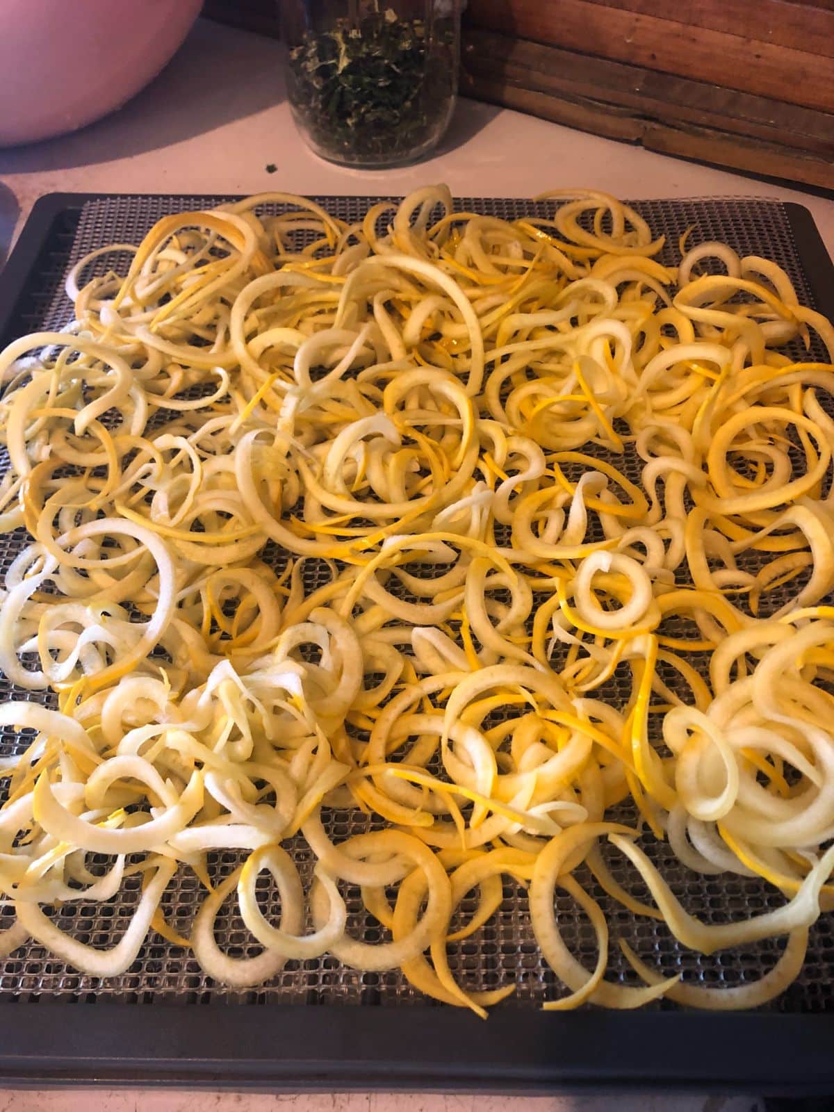 Summer squash noodles being spread out for dehydrating