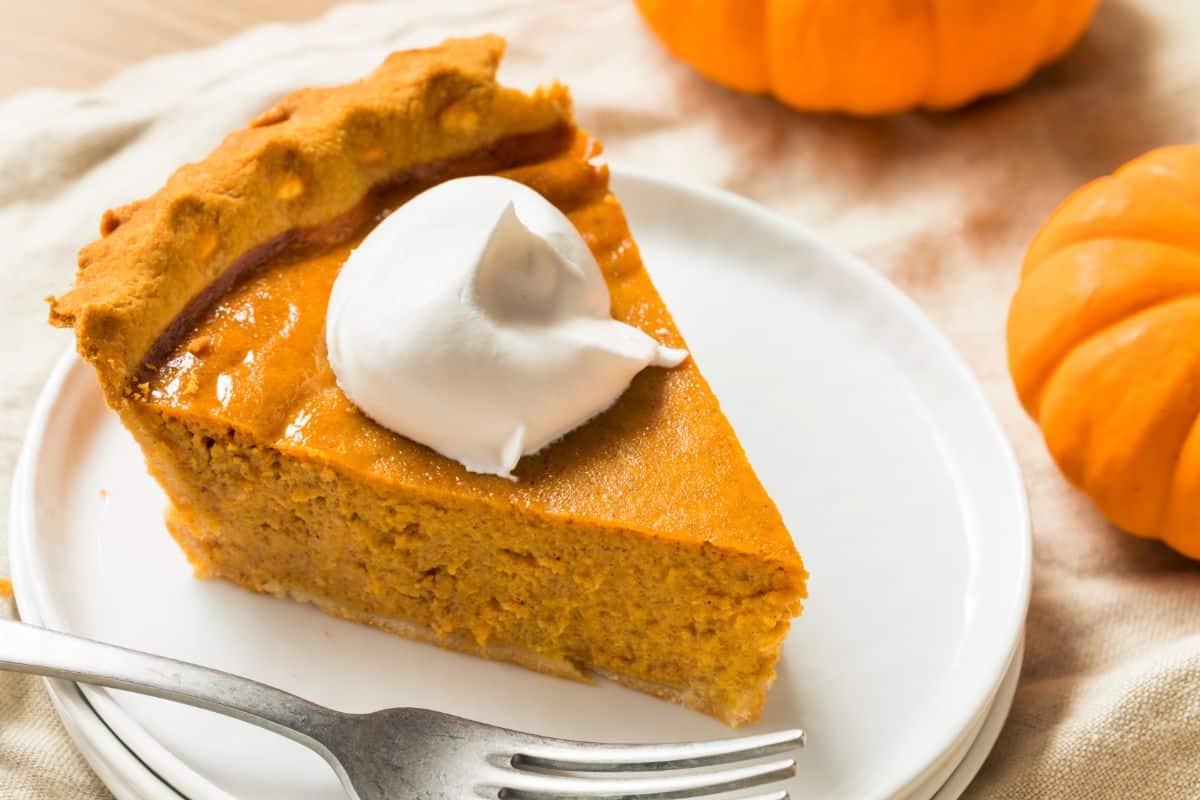 A piece of homemade pumpkin pie with cream