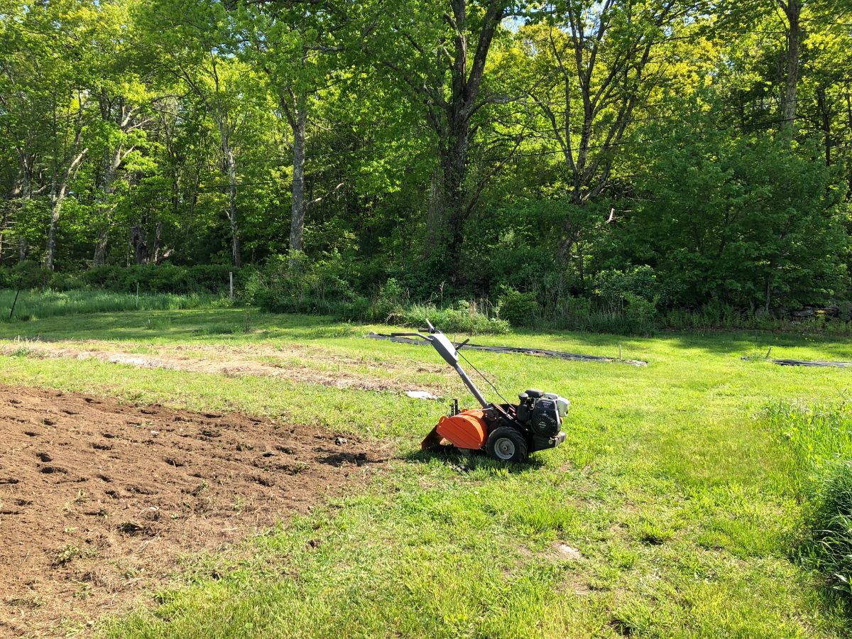 A rototiller tilling a garden section