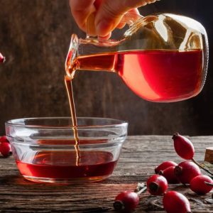 Pouring rose hip seed oil into a bowl.