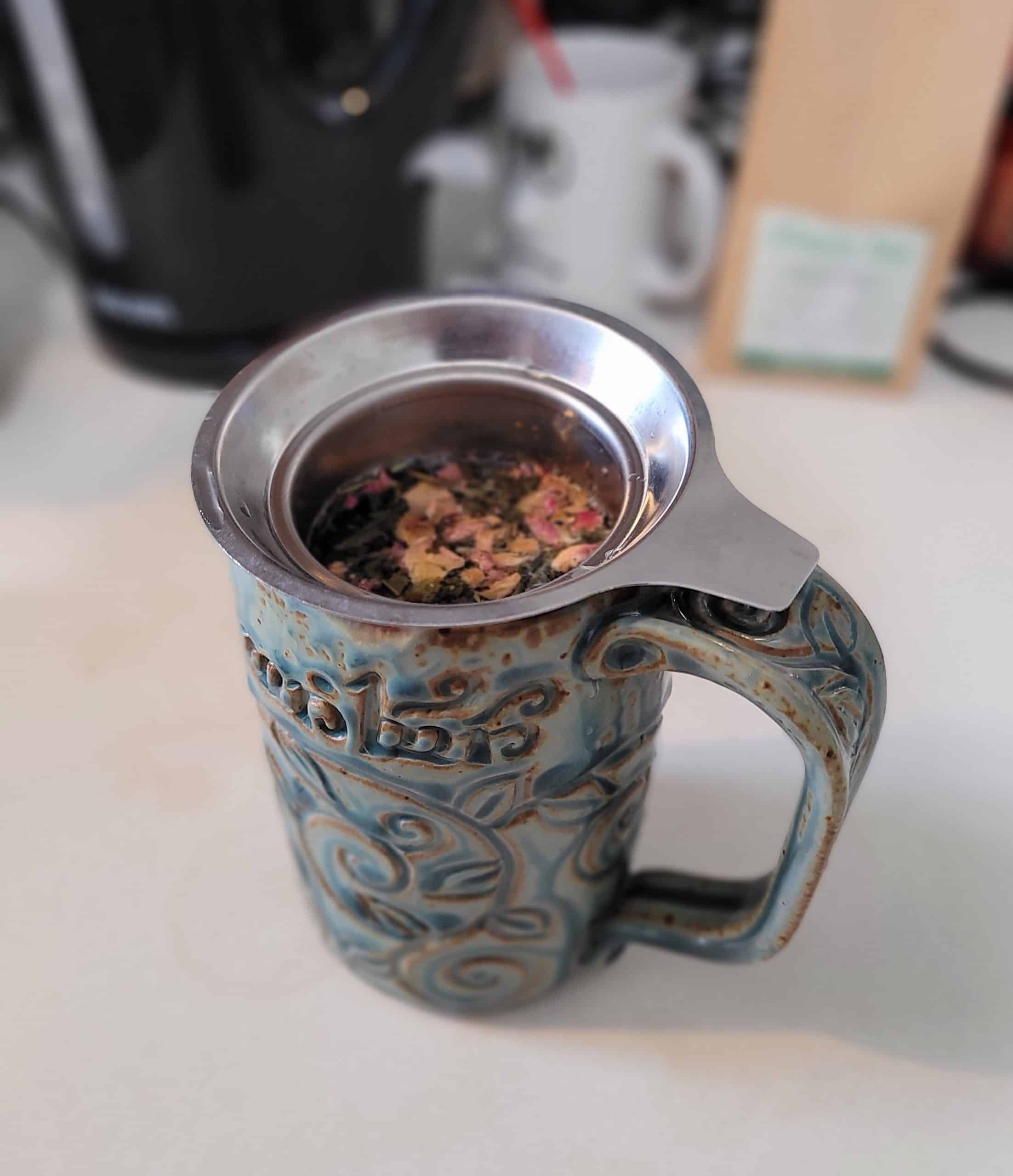 Steeping a tasty cup of green tea with rose petals.