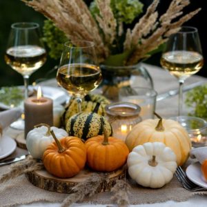 Fall table decoration with pumpkins and wine.
