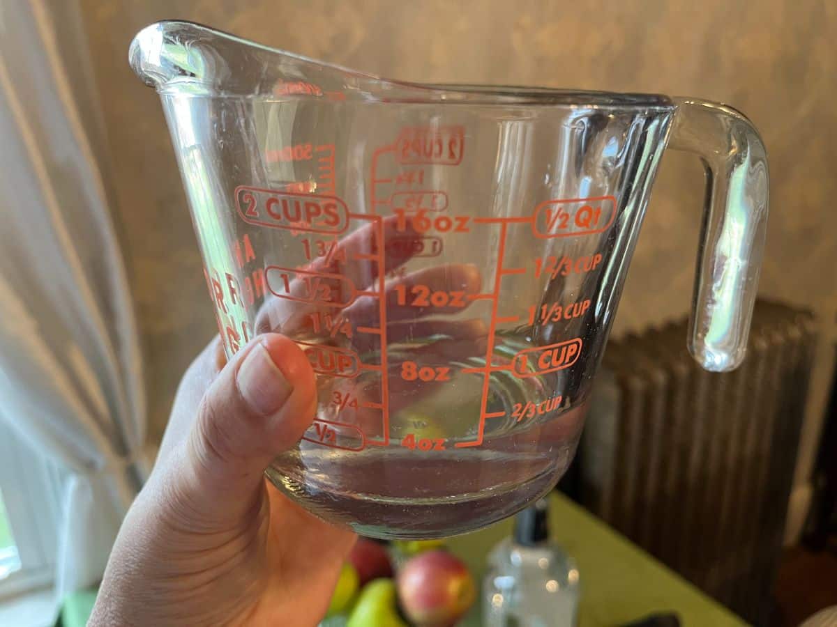 A measuring cup with water and alcohol mix for paperwhites