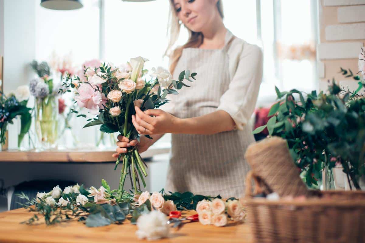 A florist working feverishly to get the bouquets finished.