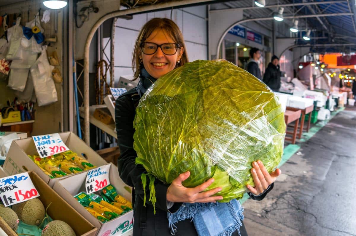 A woman holding a huge Sapporo Giant cabbage