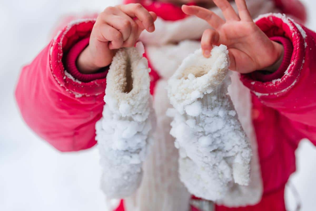 A child with snow covered mittens