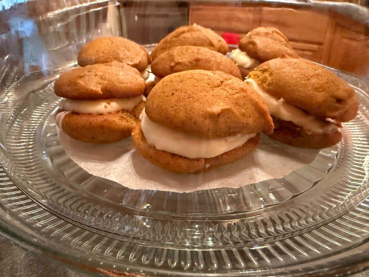 Pumpkin Whoopie pies with cream cheese filling on a cake plate